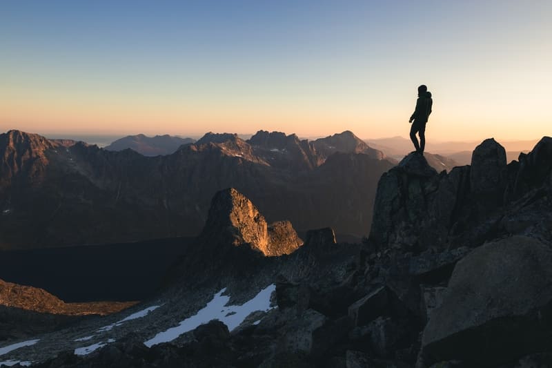 Mann steht auf Berggipfel - Atmung auf dem Berg