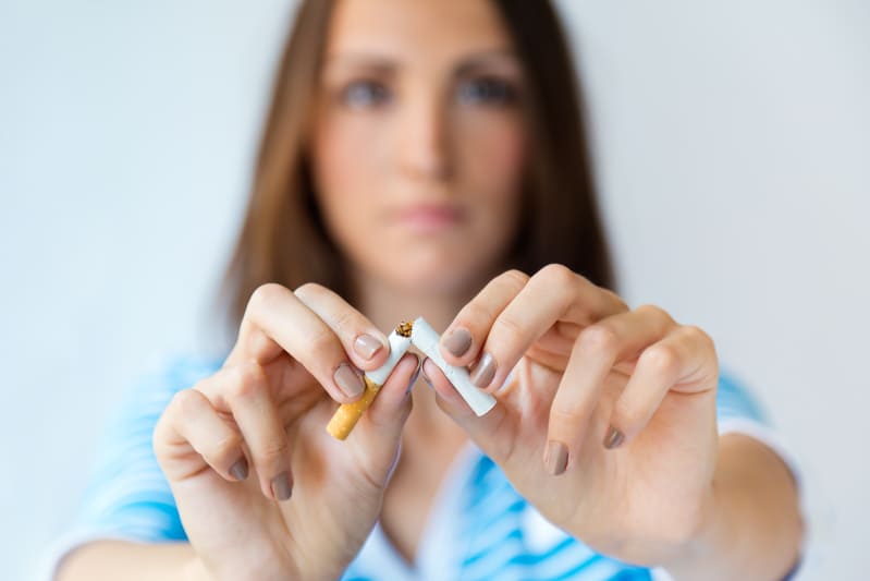 Behandlungen - Rauchentwöhnung - Frau bricht Zigarette durch